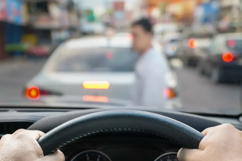A driver about to hit a pedestrian crossing the street.