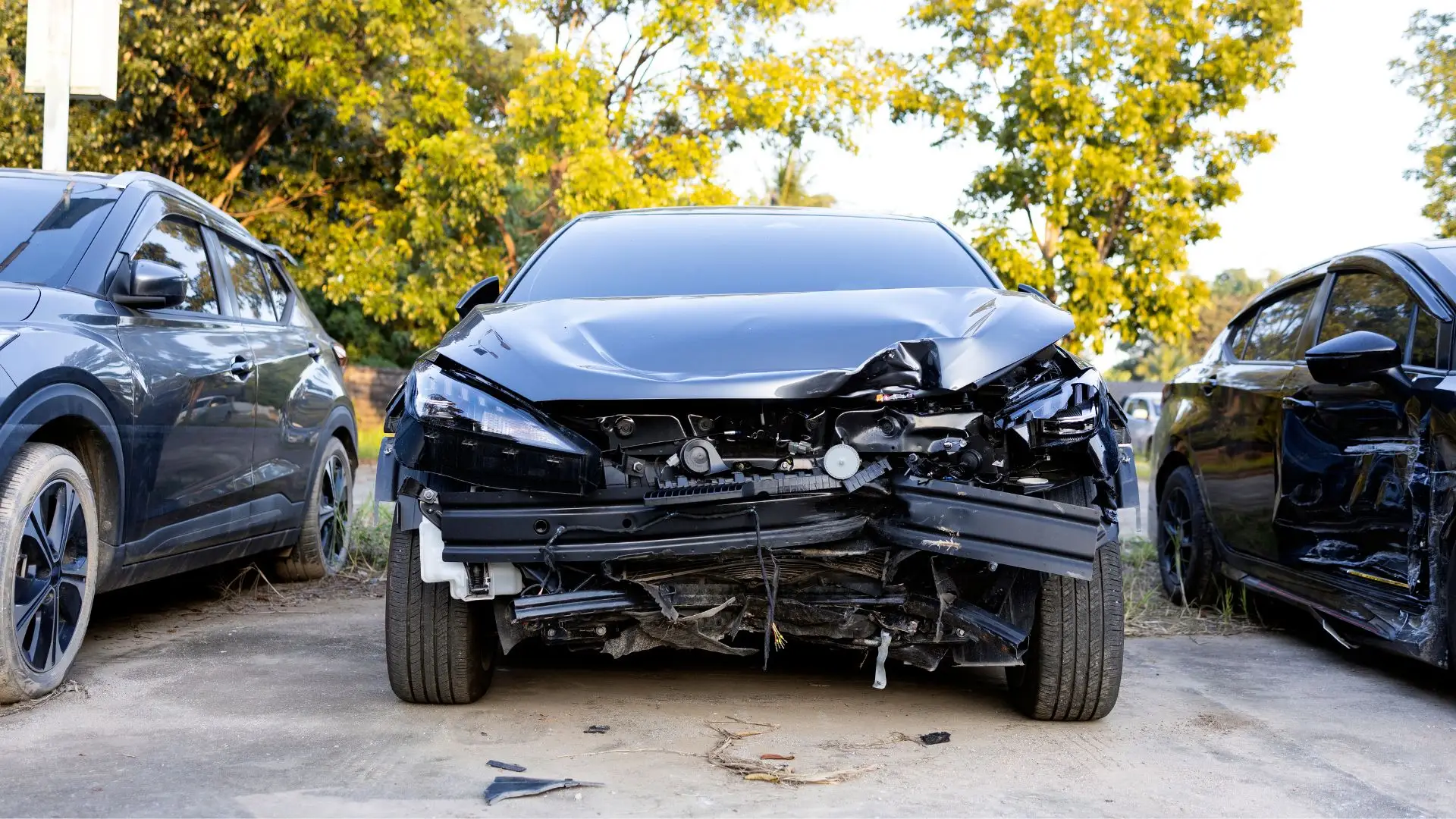 A black car with a busted front bumper.