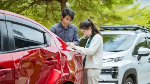 Two people exchanging contact info after a car accident.