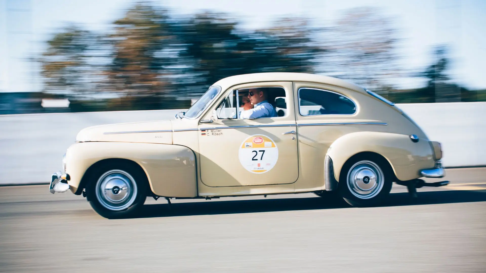 A collector car driving on a highway.