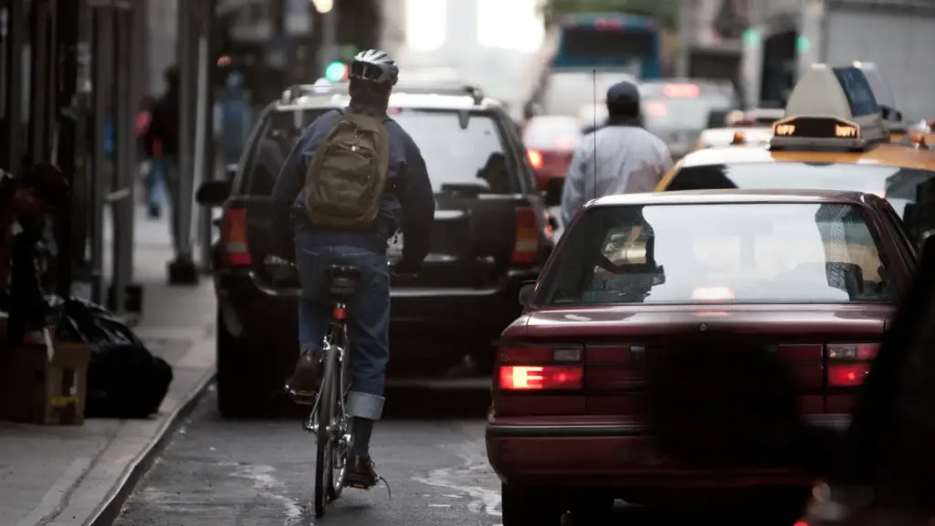 A bicyclist riding through congested traffic.