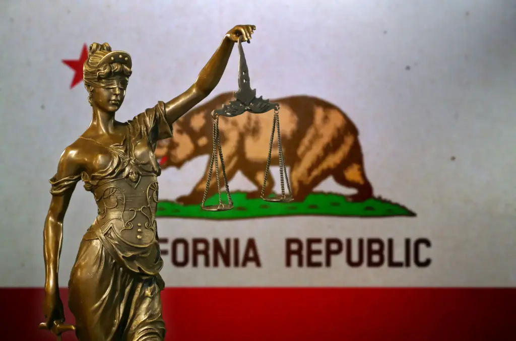 Lady justice in front of the California state flag. 