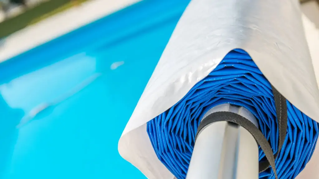 A pool tarp roll installed over a pool.