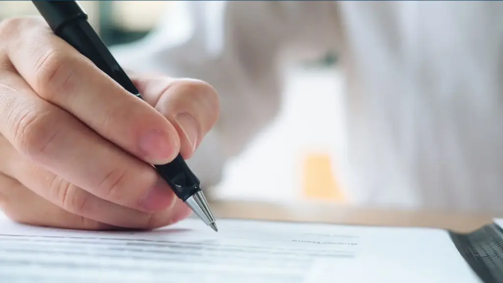 A person about to sign a document.