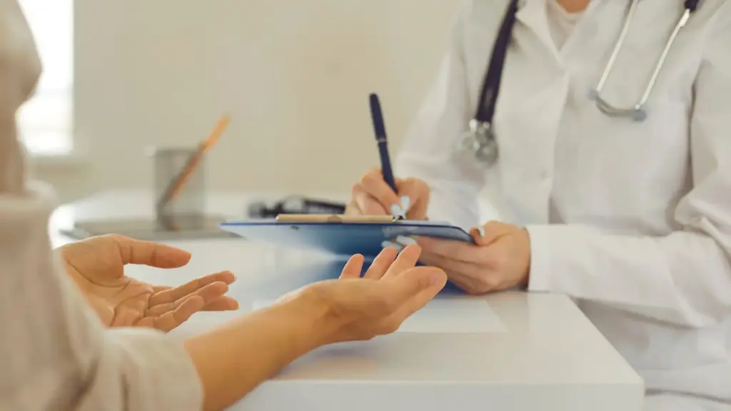 A woman talking to a doctor.
