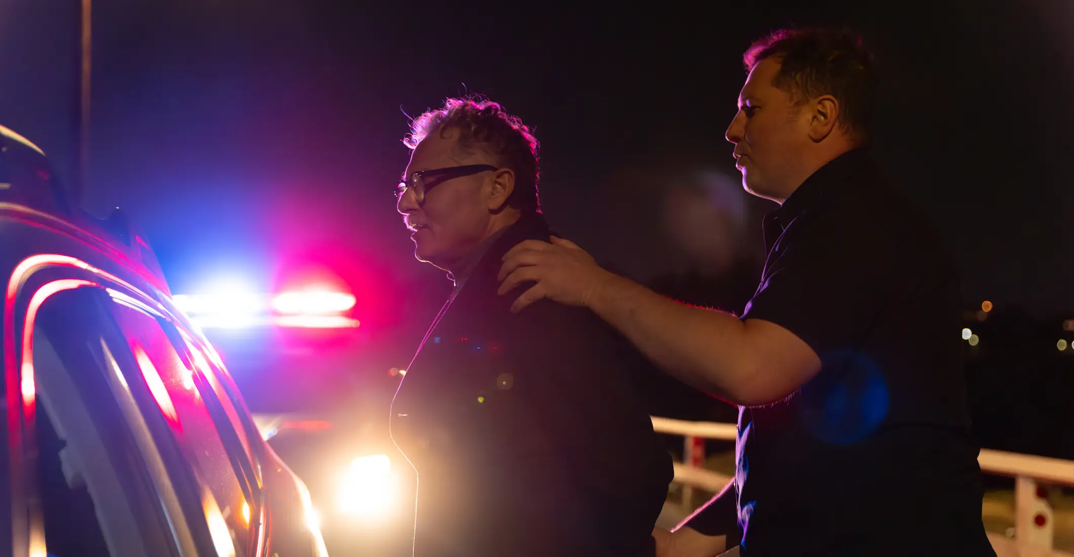 A police officer arresting a drunk driver.