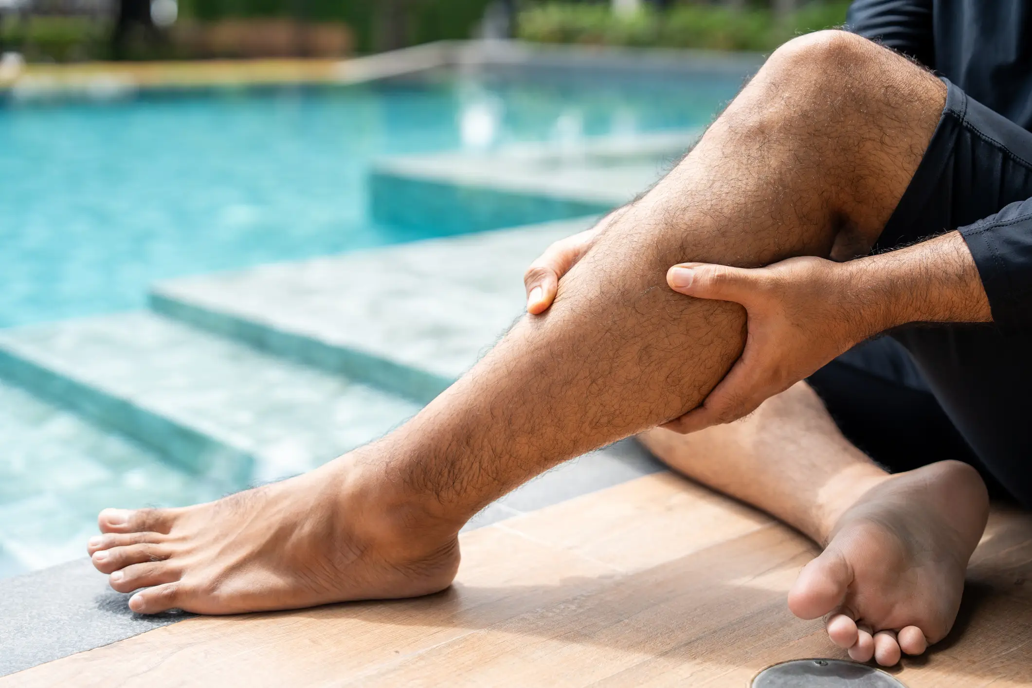A man holding onto his leg after suffering an injury.
