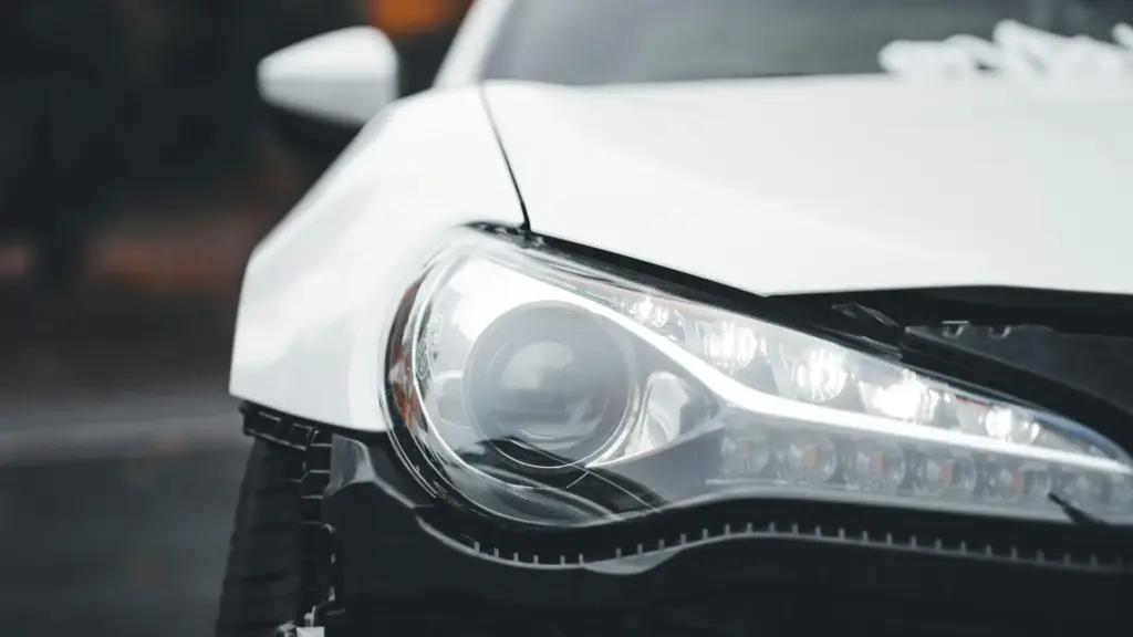 A white car with a busted front bumper.