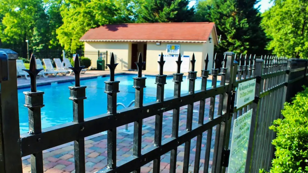 A black gate surrounding a pool.