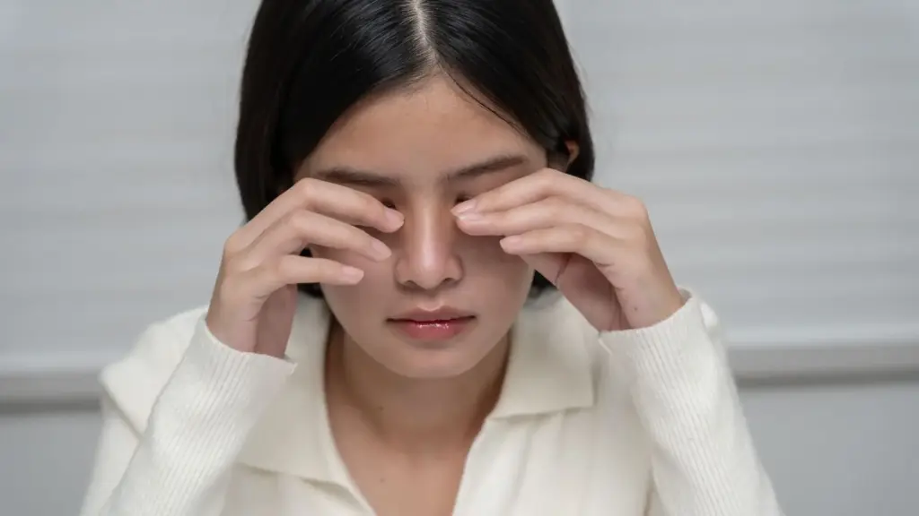 A woman rubbing her eyes.