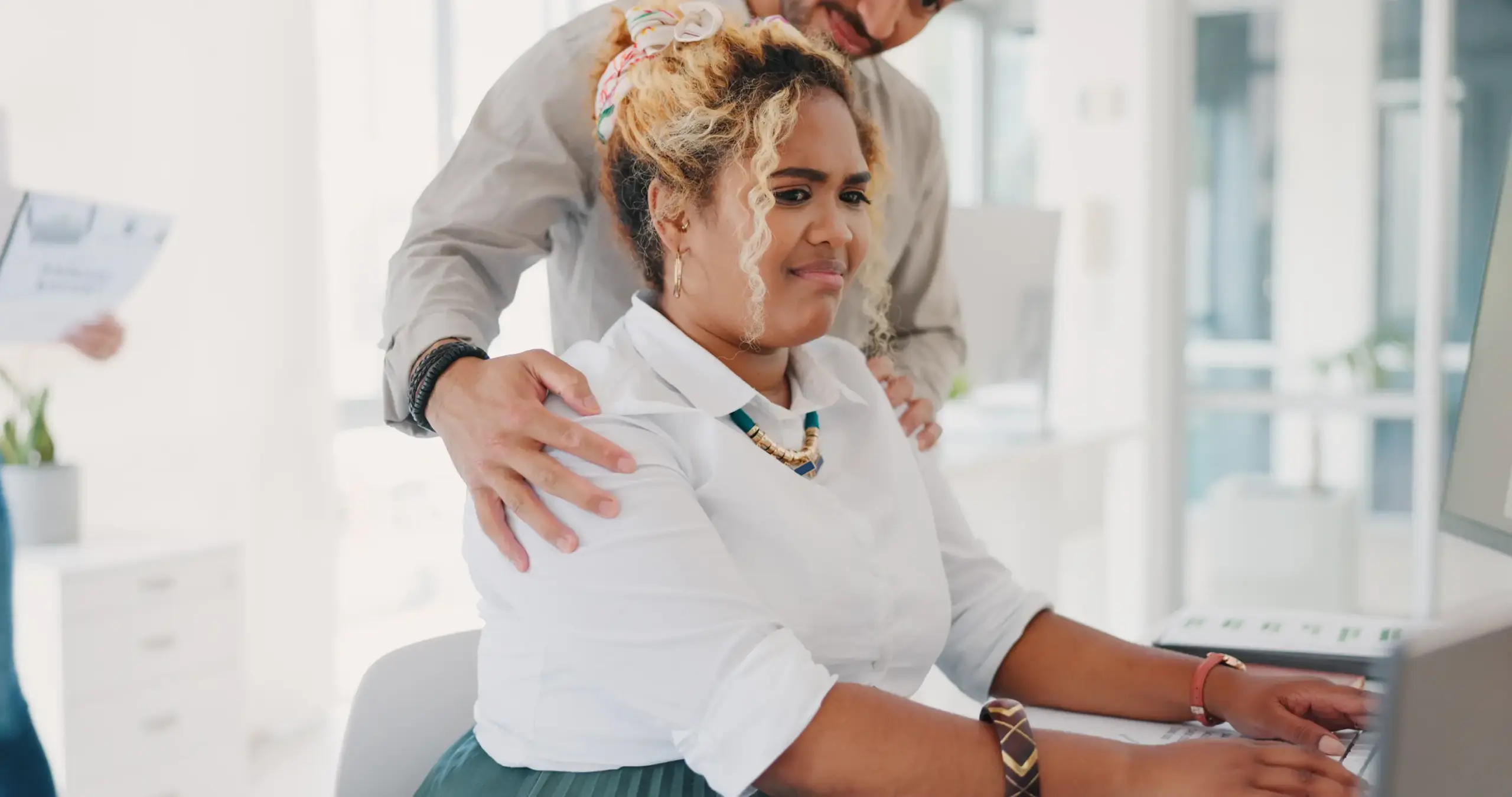A man putting his hands around an uncomfortable woman.
