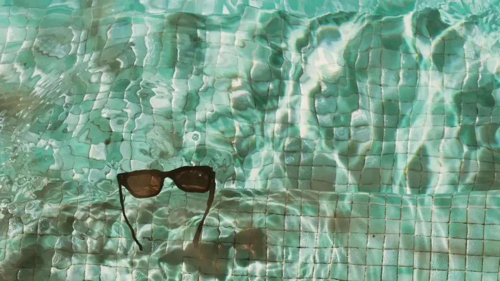 A pair of sunglasses floating in the pool.