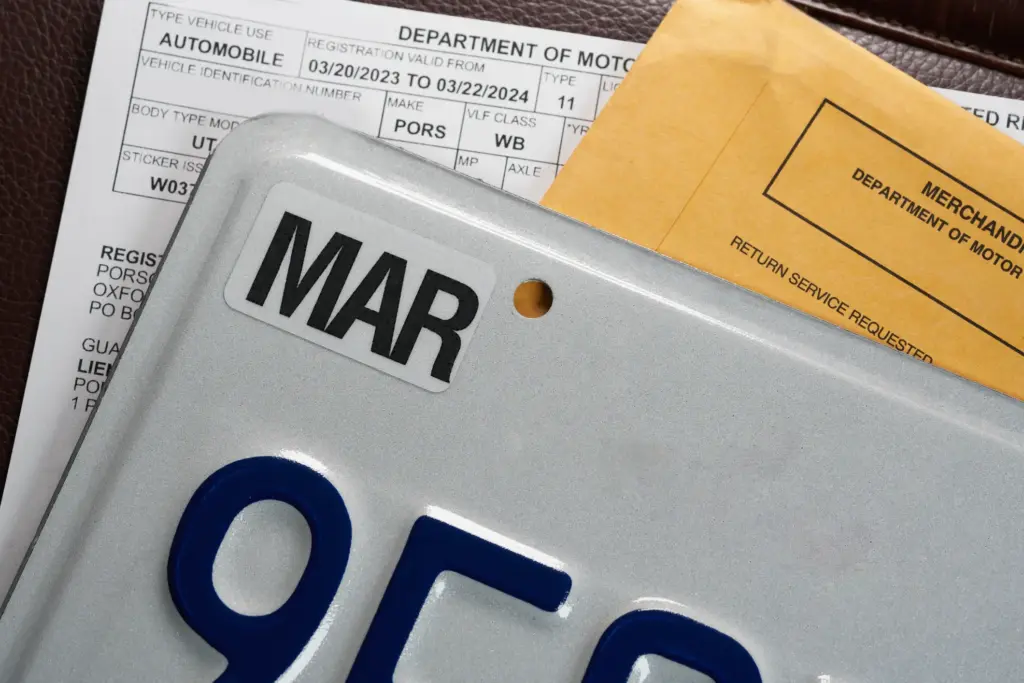 A license plate with a folder and a form from the DMV.