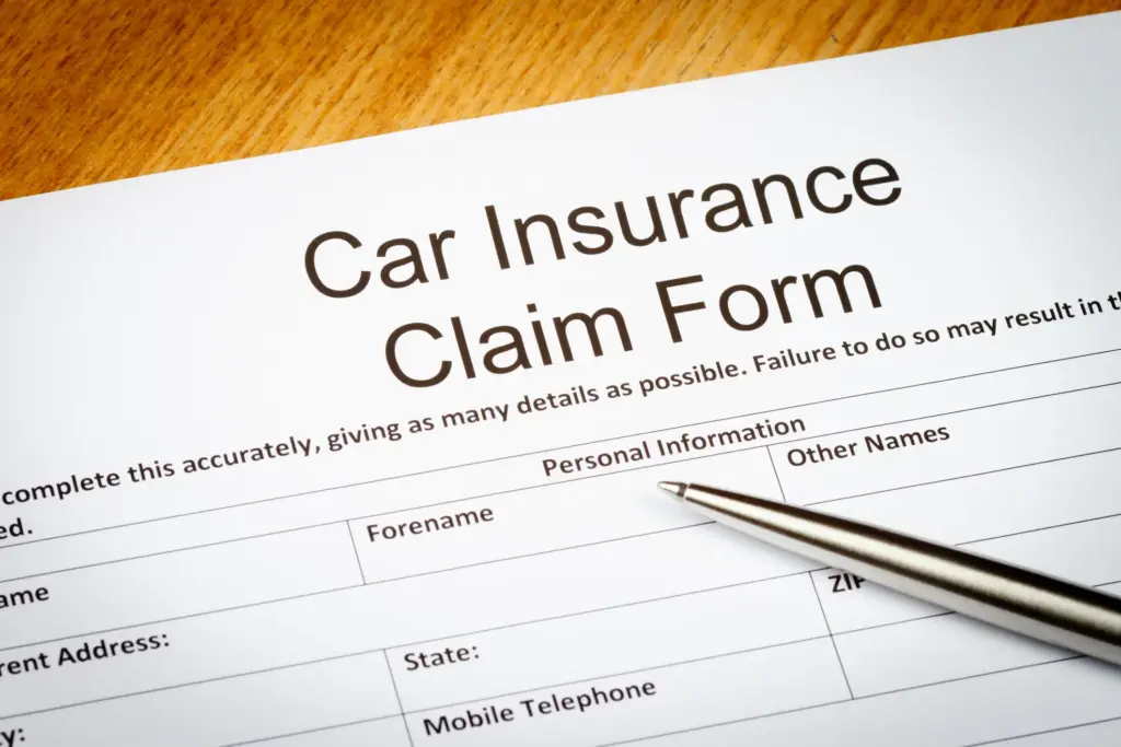 A car insurance claim form with a pen.