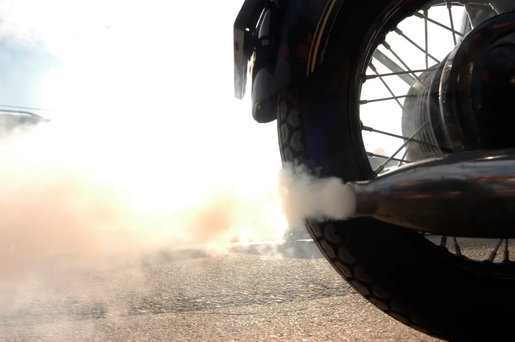A motorcycle exhausting smoke.
