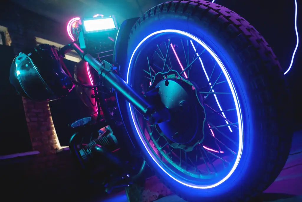 A motorcycle with colored lights and neon underglows.