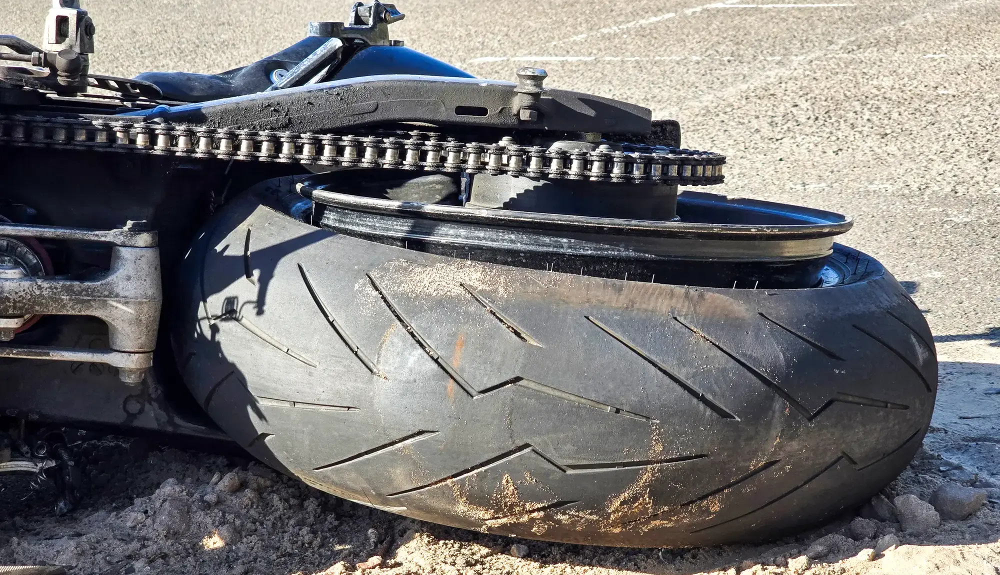 A close up of a tipped over motorcycle.