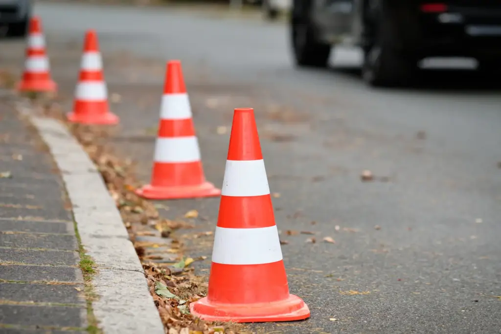 A series of traffic cones reserving street parking.
