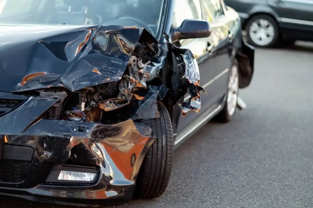 A close up of a damaged black car.