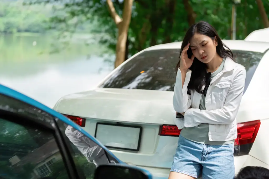 A woman in a car crash waiting for an officer to arrive.