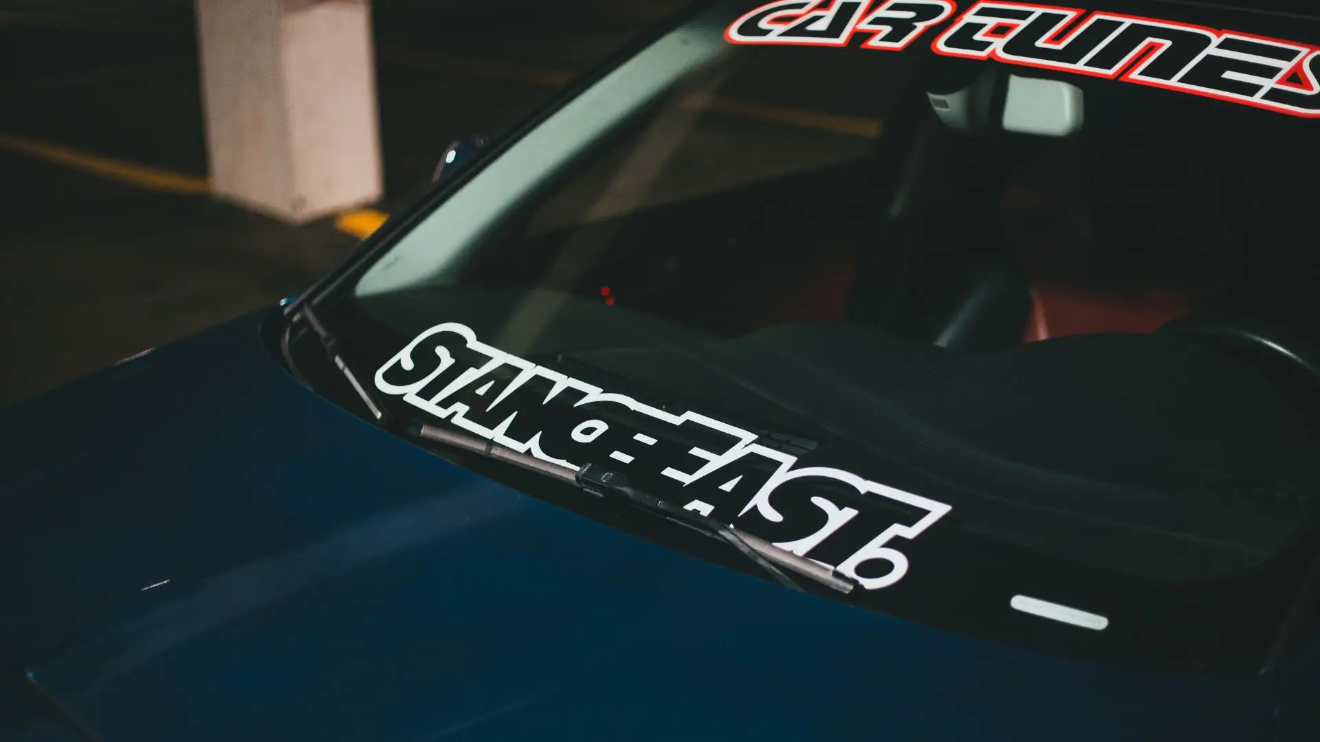 A car with large decals on the windshield.
