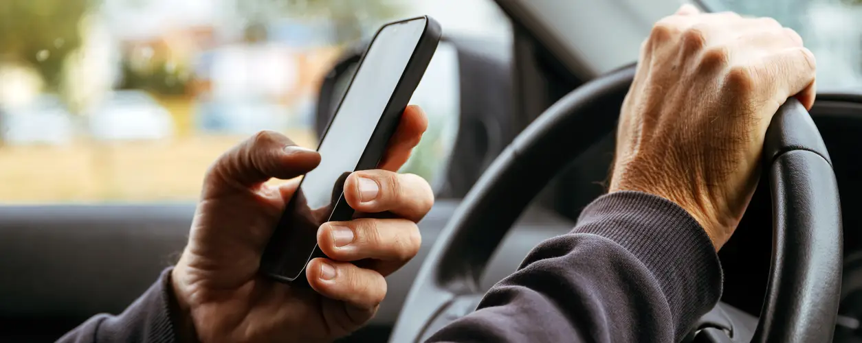 A man using his phone while behind the wheel.