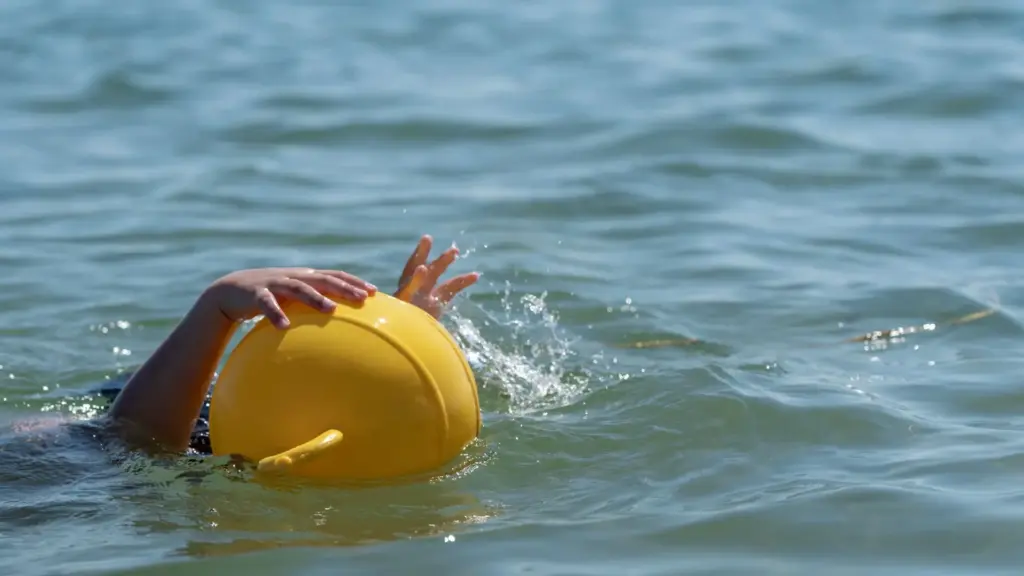 A person drowning and grabbing onto a buoy.
