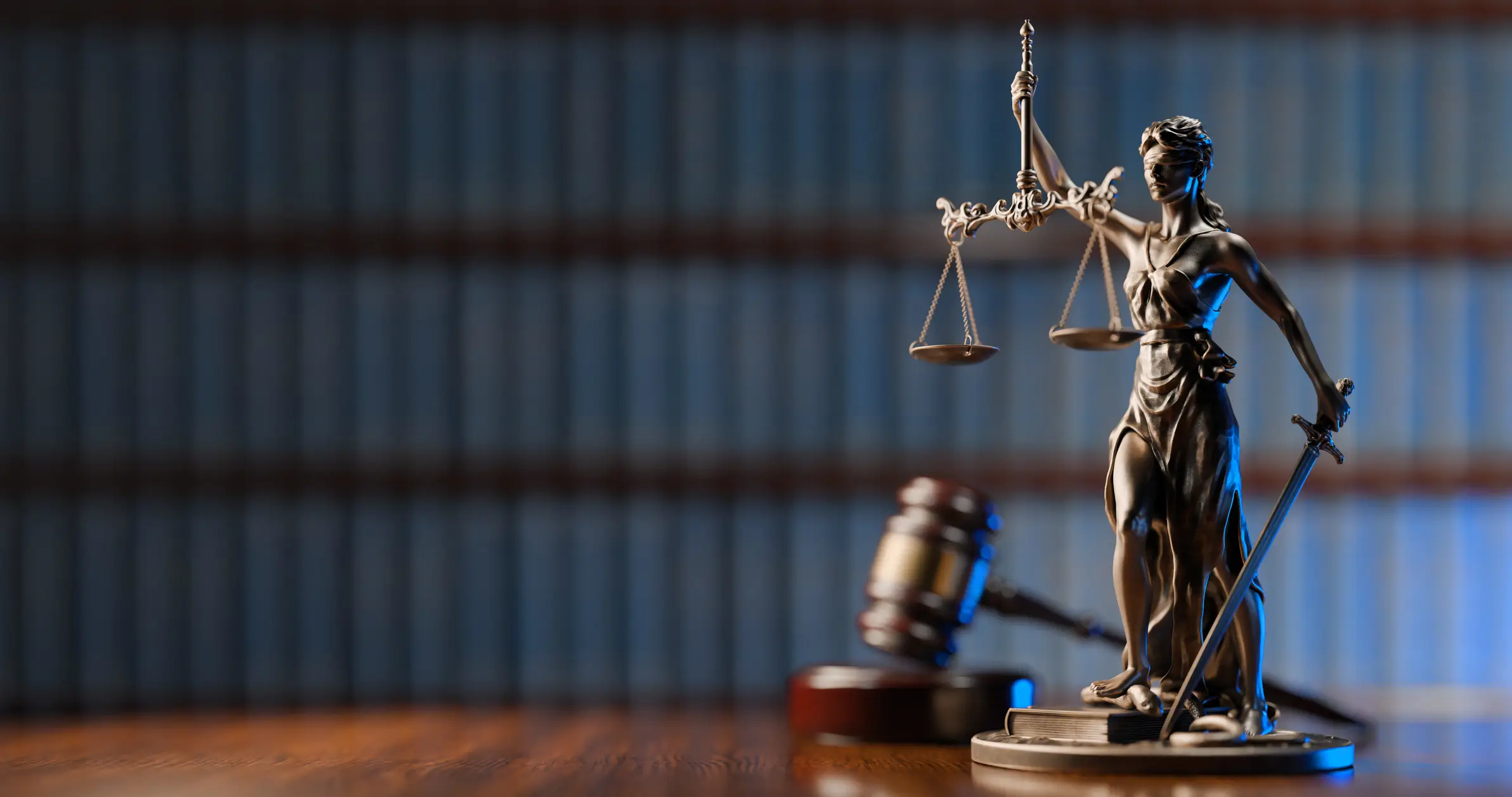 A statue of Lady Justice with a rows of book shelves behind it.