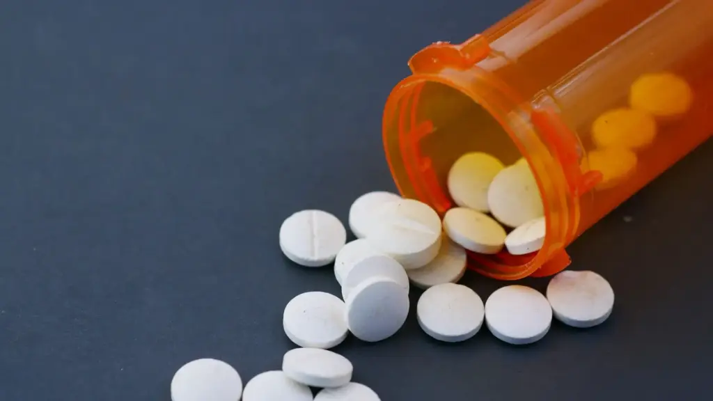 Pills on the table with an open capsule.