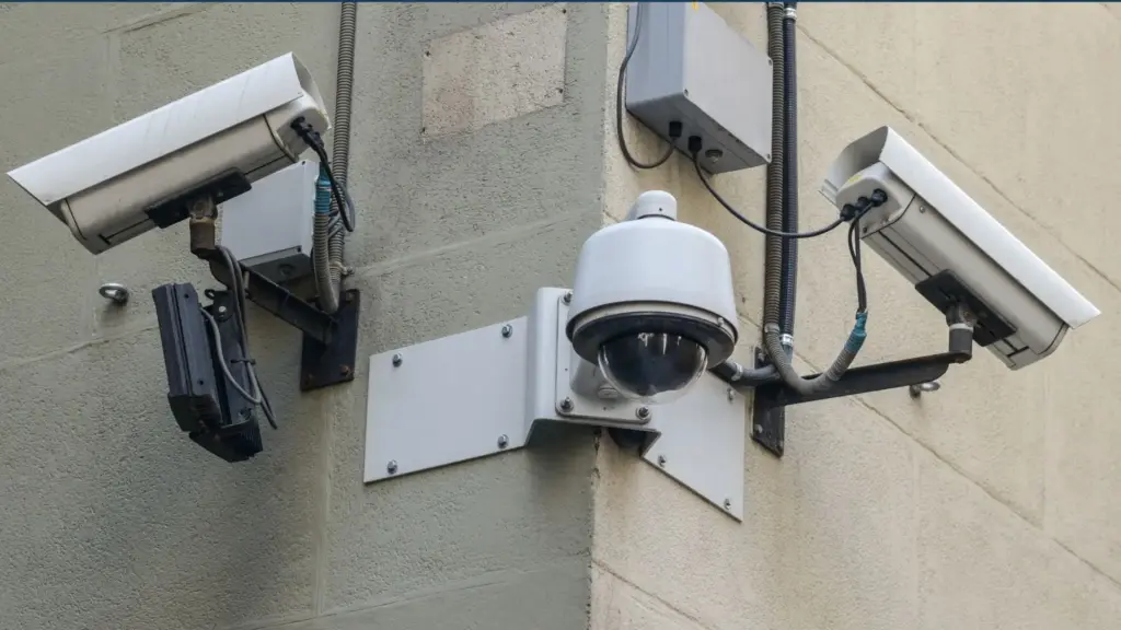 Three security cameras installed on a wall corner.