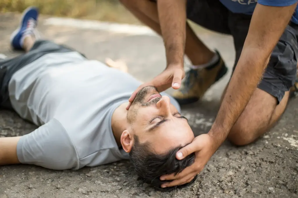 A person trying to lift a man's head.