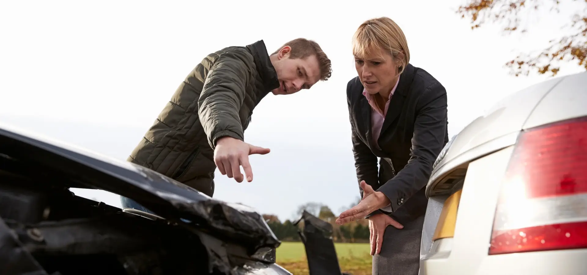 Two drivers looking at a rear end accident and talking about it.