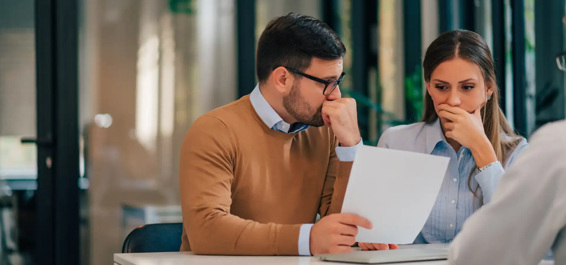 A couple reading forms from an insurance adjuster.