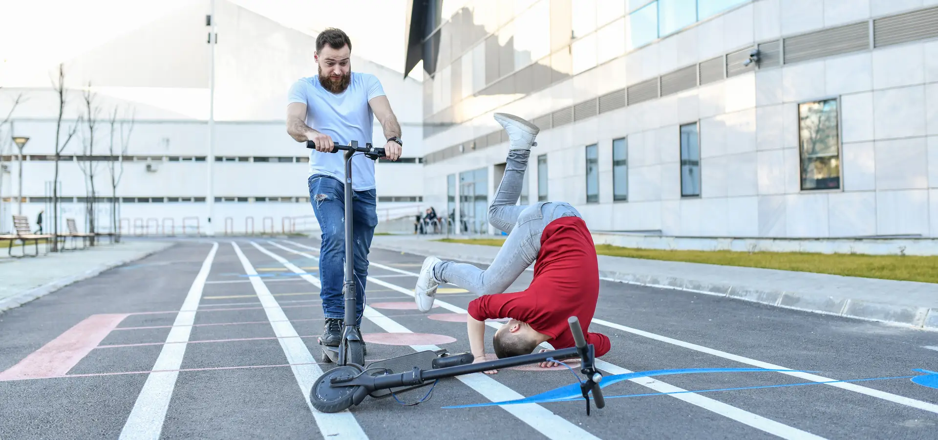 A scooter rider falling and about to cause another scooter rider to fall and crash.