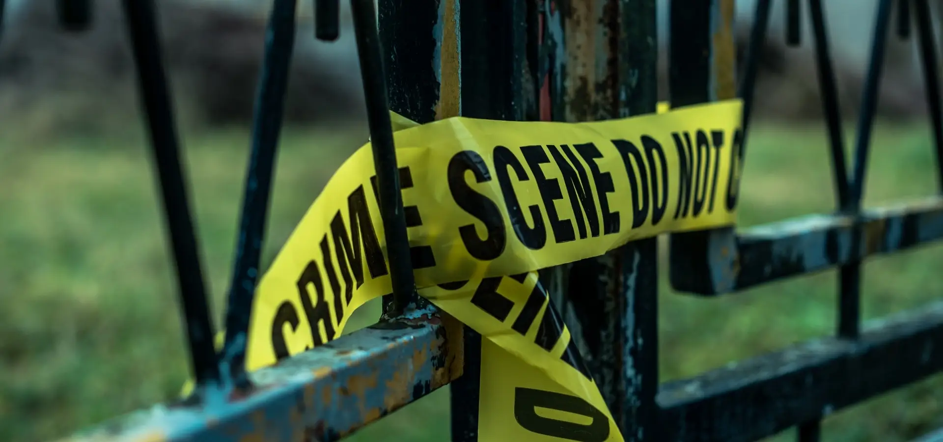 A close up of police tape on a gate.