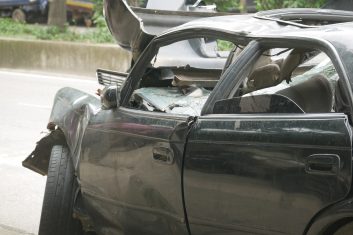 black car damaged by a road accident .